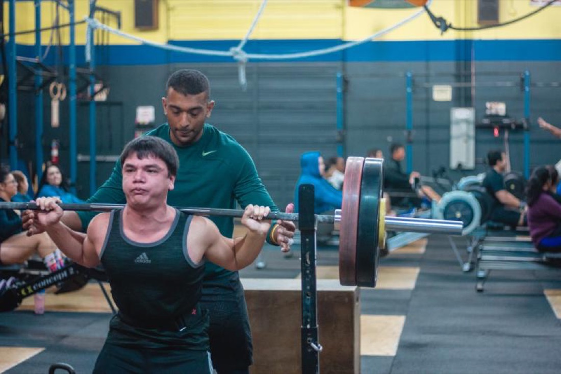Allen coaching an athlete on the barbell